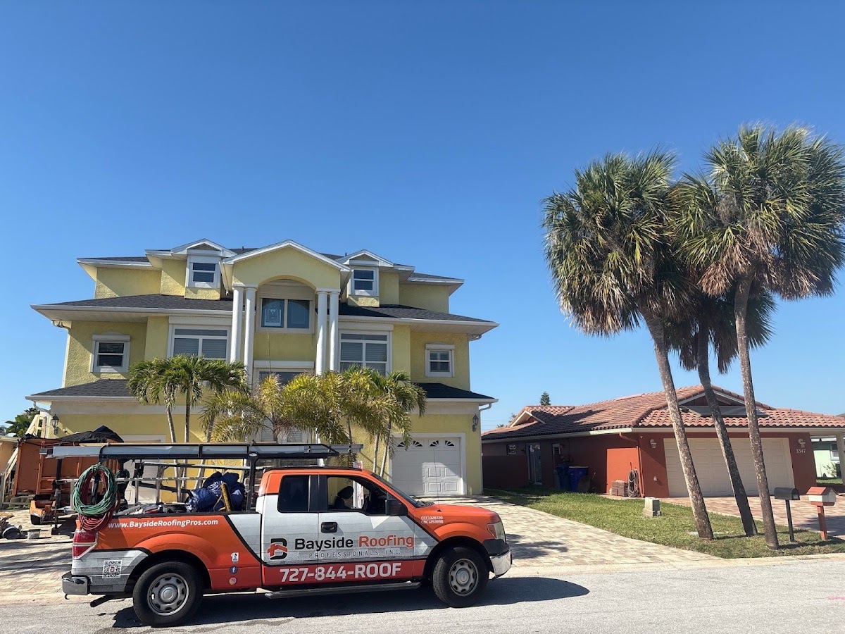 Bayside Roofing truck outside a home with a shingle roof