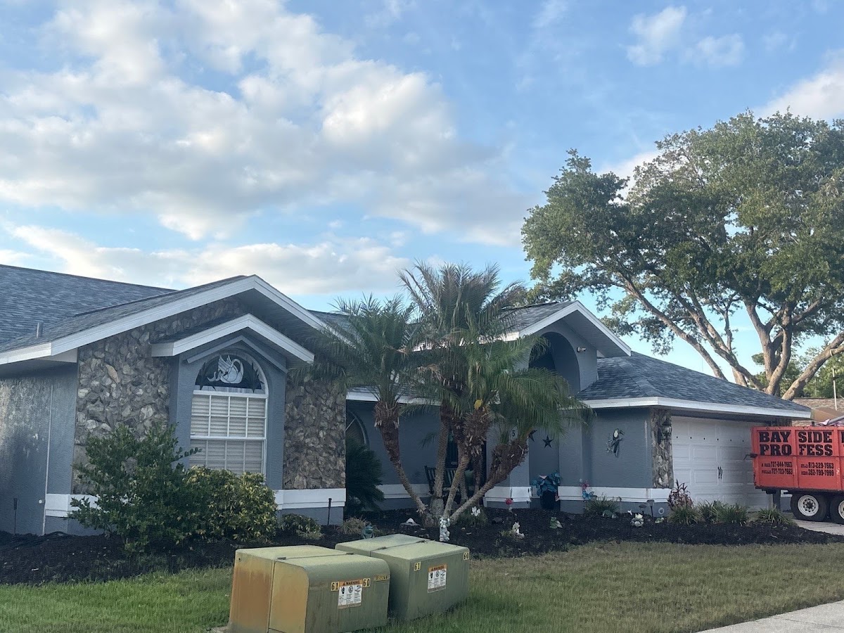 Home with a shingle roof and a Bayside project trailer